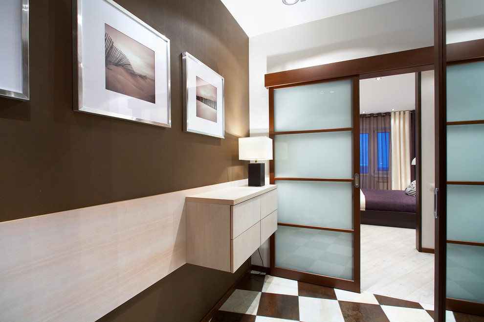 Ispirazione per un piccolo corridoio design con pareti marroni, pavimento in gres porcellanato e pavimento marrone