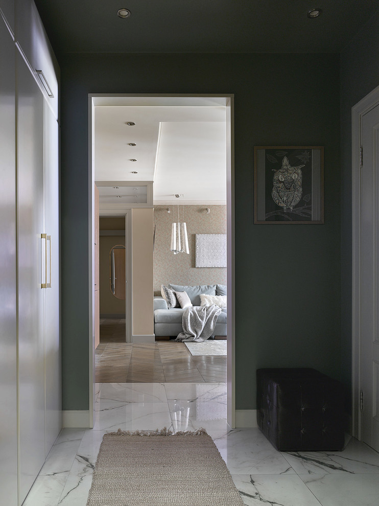 Cette image montre une petite entrée design avec un mur vert, un sol en carrelage de porcelaine et un sol blanc.