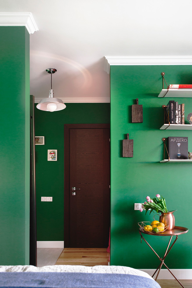 На фото: прихожая в современном стиле с зелеными стенами и входной дверью из темного дерева с