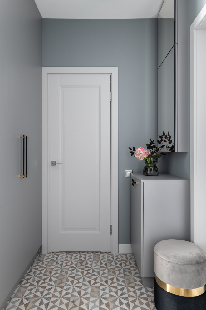 Ispirazione per un piccolo corridoio contemporaneo con pareti grigie, pavimento in gres porcellanato, una porta singola, una porta grigia e pavimento grigio