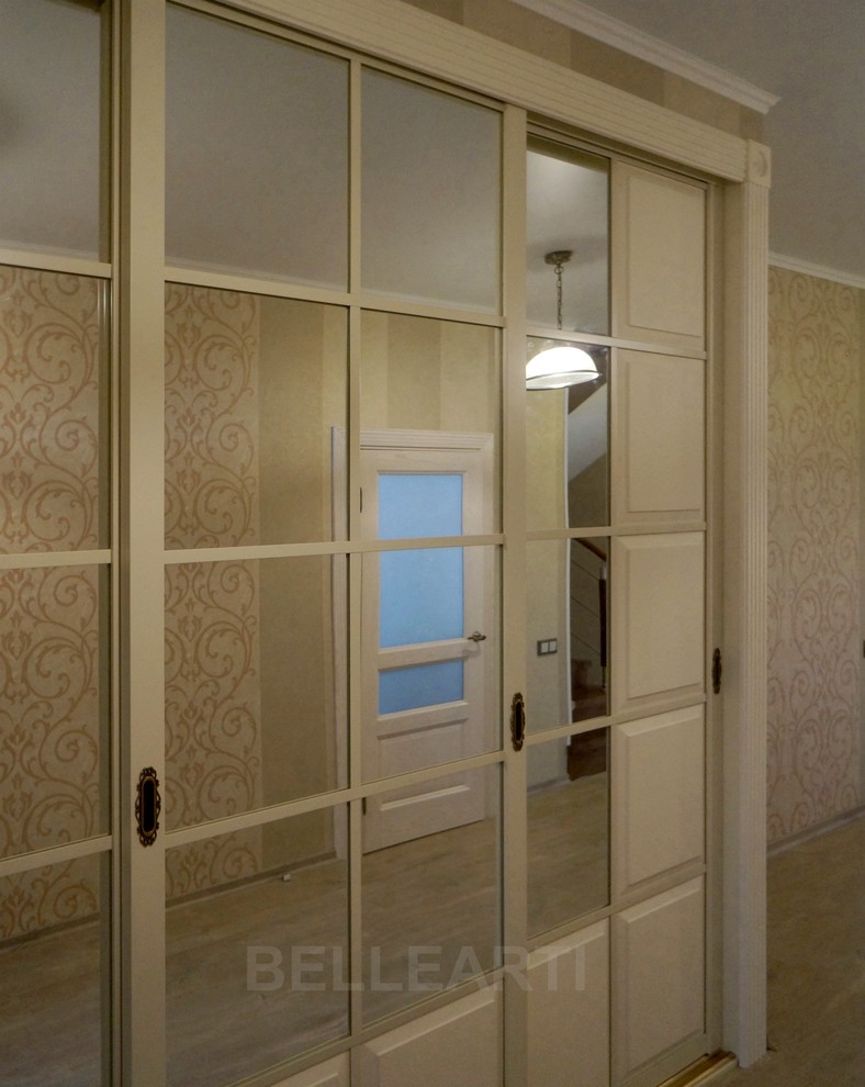 Réalisation d'une entrée tradition de taille moyenne avec un couloir, un mur beige, une porte blanche, sol en stratifié et un sol beige.