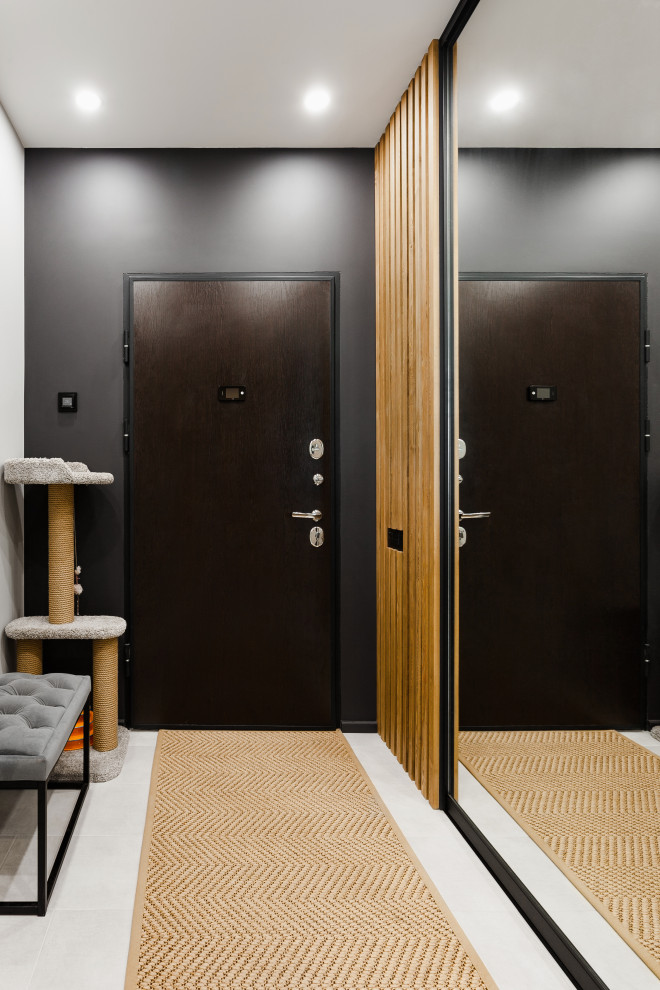 Idee per una piccola porta d'ingresso design con pareti nere, pavimento in gres porcellanato, una porta singola, una porta in legno scuro, pavimento grigio e pannellatura