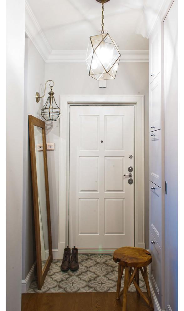 На фото: маленькая узкая прихожая в современном стиле с разноцветными стенами, темным паркетным полом, одностворчатой входной дверью, белой входной дверью и коричневым полом для на участке и в саду