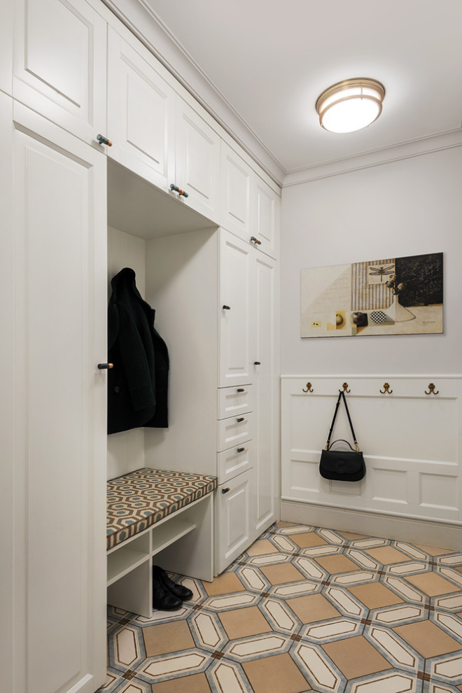 На фото: прихожая со шкафом для обуви в стиле неоклассика (современная классика) с белыми стенами и бежевым полом с