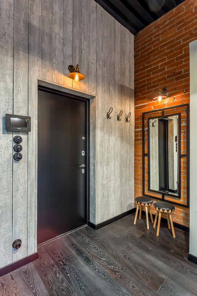 Industrial Foyer mit bunten Wänden, dunklem Holzboden, Einzeltür und schwarzer Haustür in Moskau
