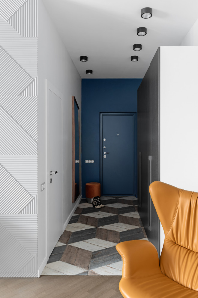 Idee per un corridoio design di medie dimensioni con pareti bianche, una porta singola, una porta blu e pavimento multicolore