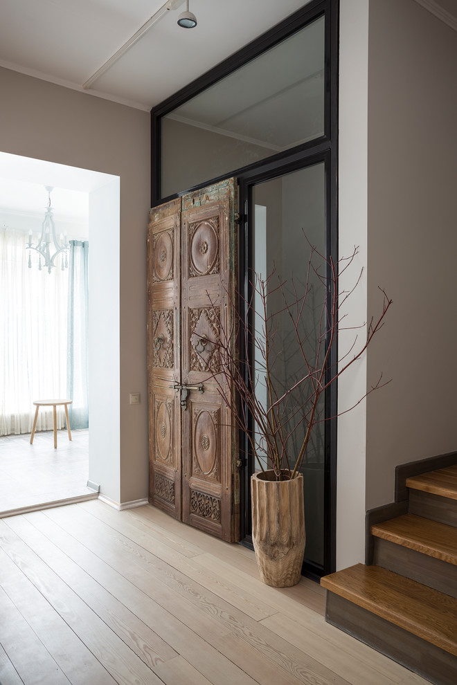 Eclectic entrance in Moscow with white walls, light hardwood flooring and beige floors.