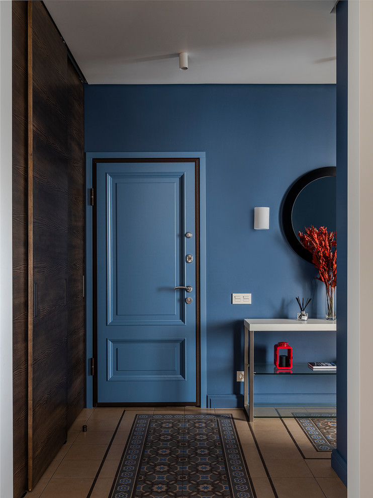 Idéer för mellanstora funkis ingångspartier, med blå väggar, klinkergolv i keramik, en enkeldörr, en blå dörr och beiget golv