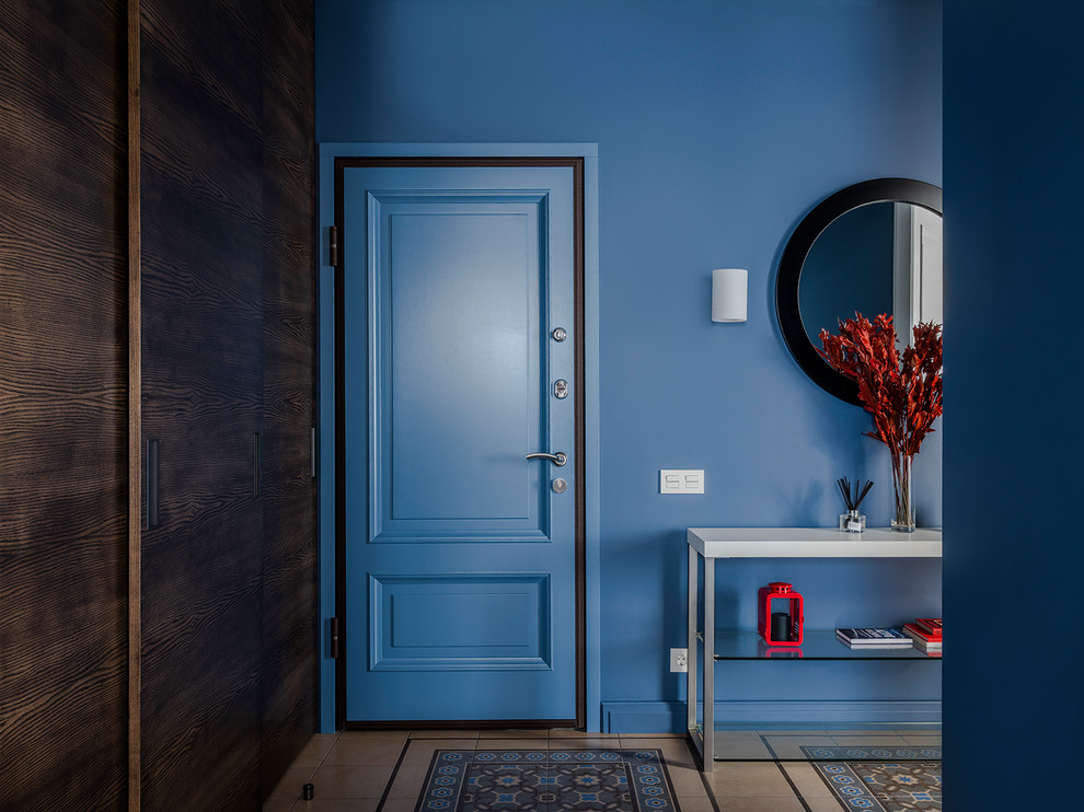 На фото: входная дверь среднего размера в стиле неоклассика (современная классика) с синими стенами, полом из керамической плитки, одностворчатой входной дверью, синей входной дверью и разноцветным полом с
