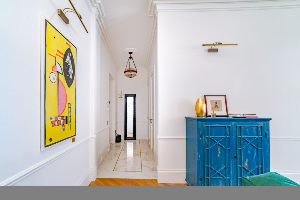 На фото: узкая прихожая среднего размера в стиле модернизм с белыми стенами, полом из керамогранита, одностворчатой входной дверью, белой входной дверью и белым полом