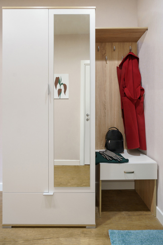 Cette photo montre une petite entrée tendance avec un couloir, un mur beige, un sol en vinyl, un sol marron et du papier peint.