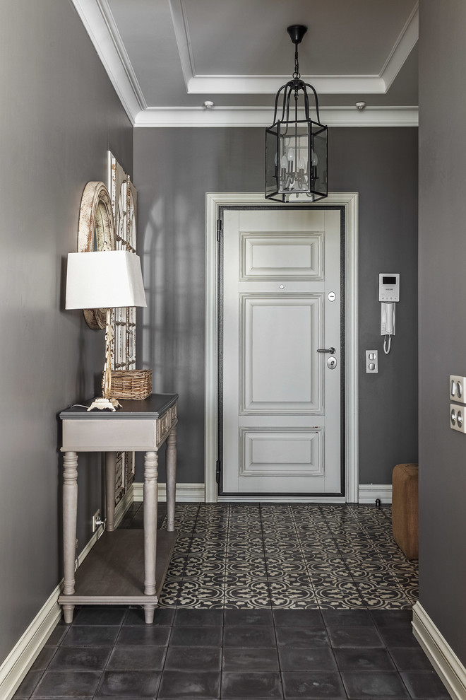 Стильный дизайн: входная дверь среднего размера: освещение в классическом стиле с серыми стенами, бетонным полом, одностворчатой входной дверью, белой входной дверью и серым полом - последний тренд