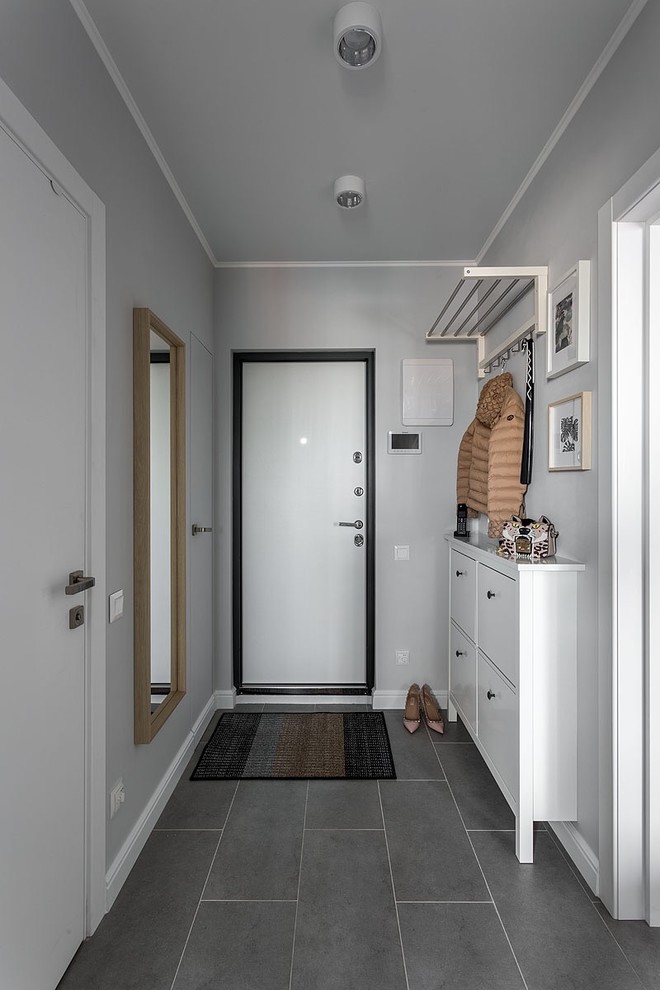 Photo of a scandi front door in Moscow with white walls, a single front door, a white front door and grey floors.