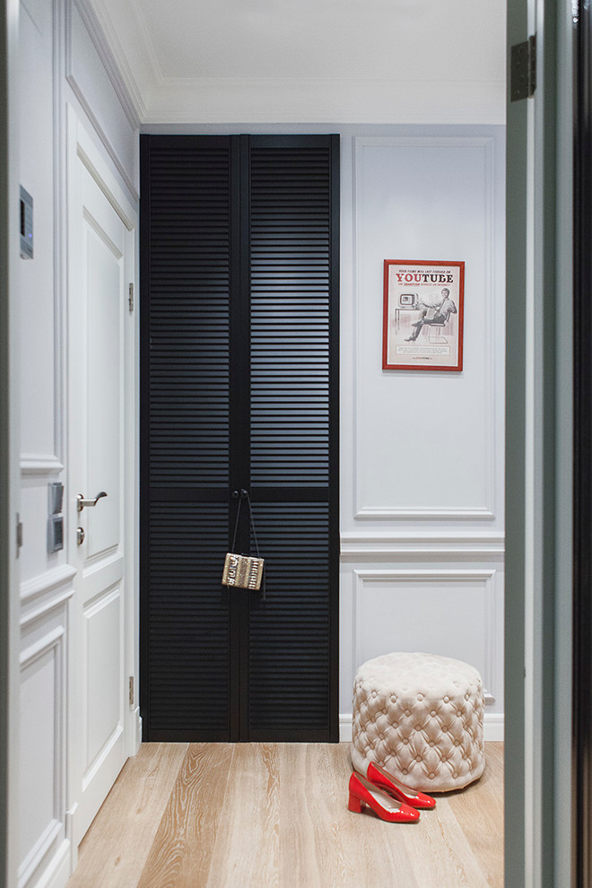 Foto på en vintage entré, med vita väggar, ljust trägolv, en enkeldörr och en vit dörr