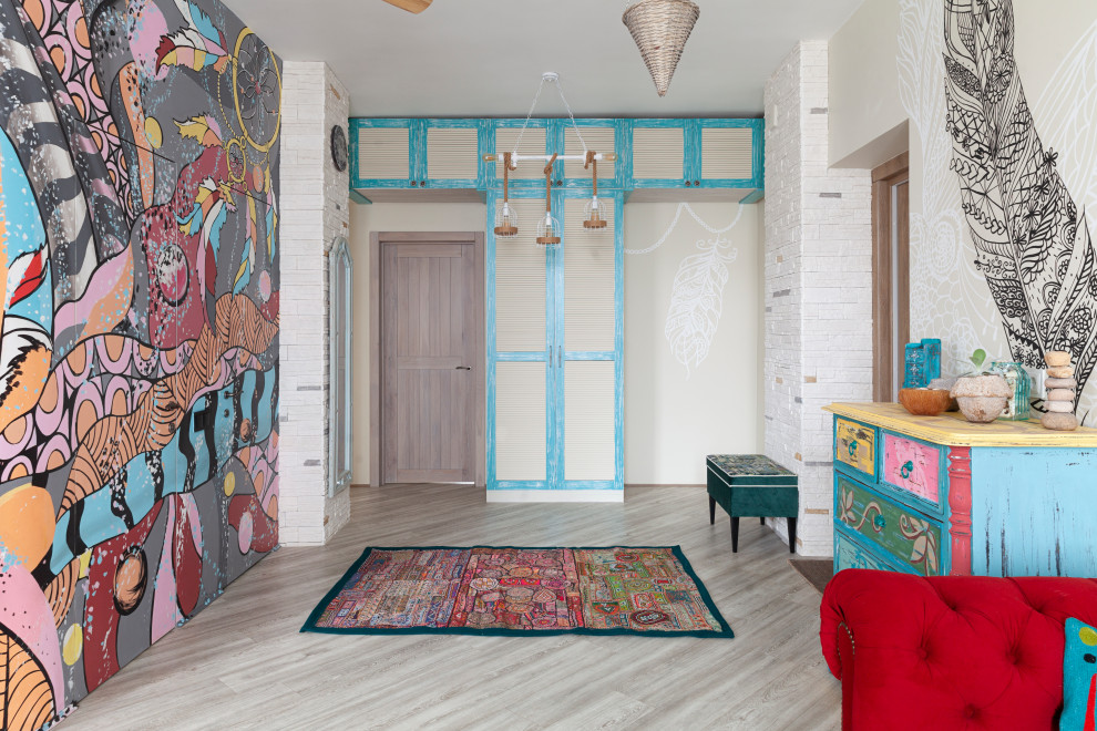 Cette image montre une entrée bohème avec un mur multicolore, une porte simple, une porte en bois brun et un sol gris.