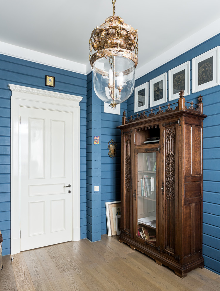 This is an example of a country entrance in Moscow with blue walls, light hardwood flooring and beige floors.