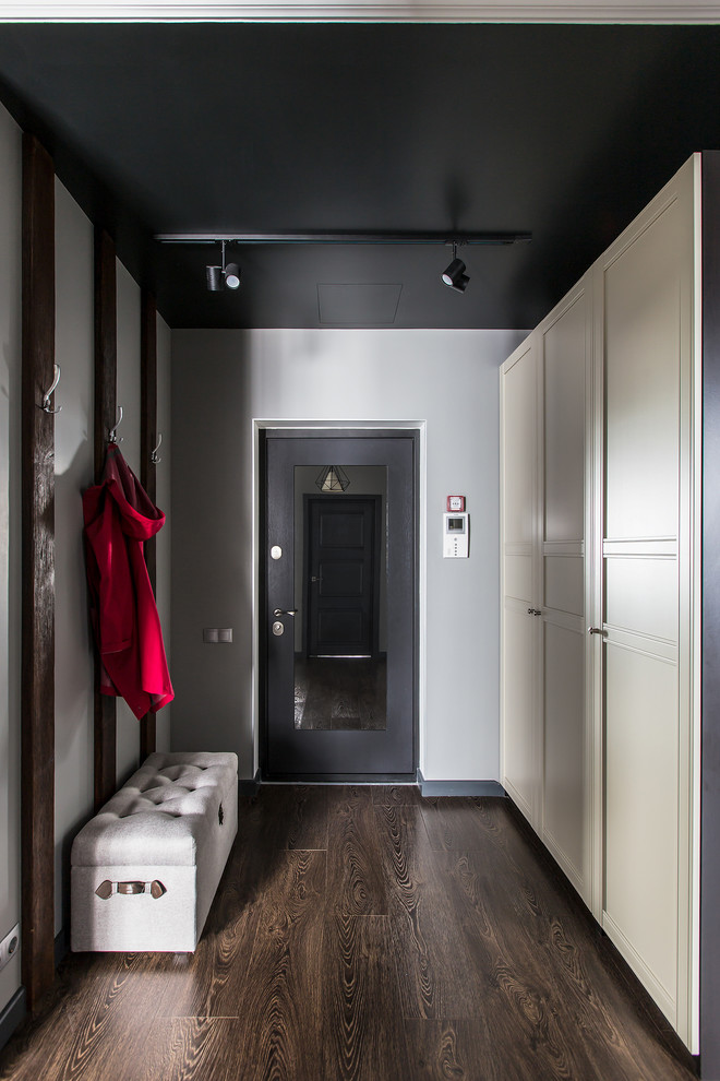 Ejemplo de puerta principal actual con paredes grises, suelo de madera oscura, puerta simple, puerta negra y suelo marrón