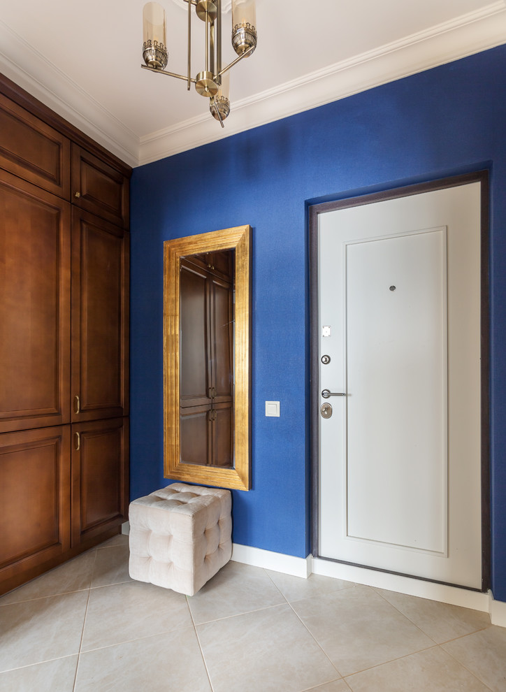 На фото: входная дверь в стиле неоклассика (современная классика) с синими стенами, одностворчатой входной дверью и белой входной дверью