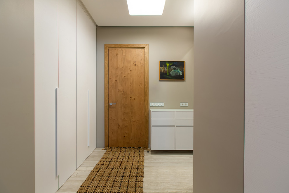 Пример оригинального дизайна: прихожая среднего размера в скандинавском стиле с серыми стенами, полом из керамогранита, одностворчатой входной дверью, входной дверью из дерева среднего тона и белым полом