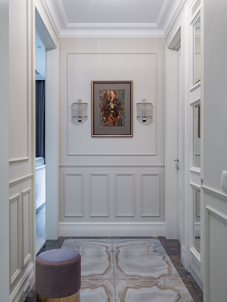 На фото: вестибюль среднего размера в стиле неоклассика (современная классика) с бежевыми стенами, полом из керамогранита, одностворчатой входной дверью, входной дверью из дерева среднего тона, синим полом и панелями на части стены с