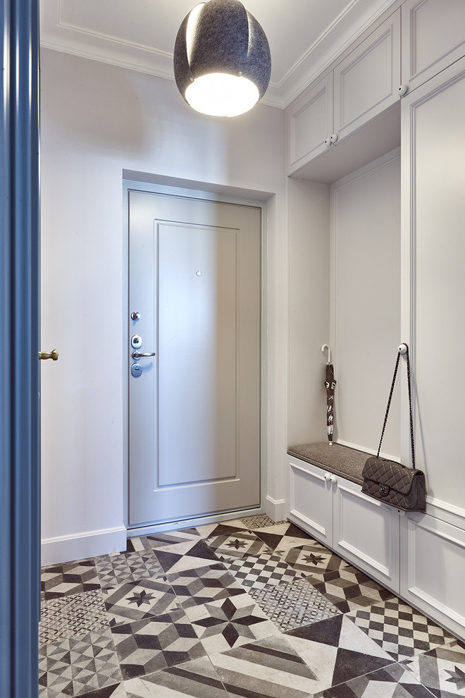 Modern inredning av en ingång och ytterdörr, med grå väggar, en enkeldörr, en grå dörr och flerfärgat golv