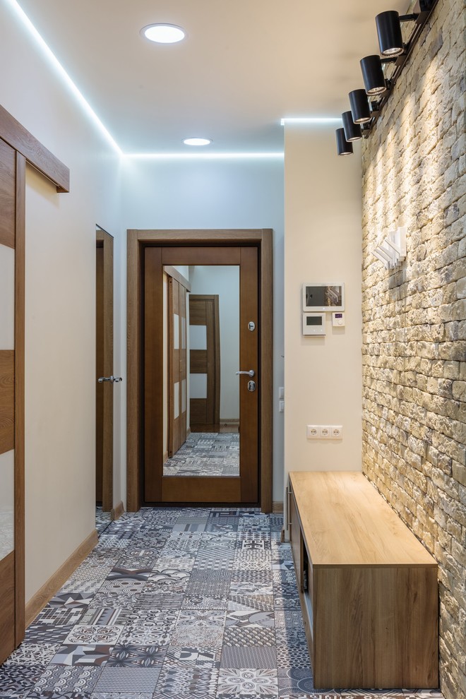 Esempio di un grande corridoio nordico con pareti bianche, pavimento in legno massello medio, una porta singola e una porta marrone