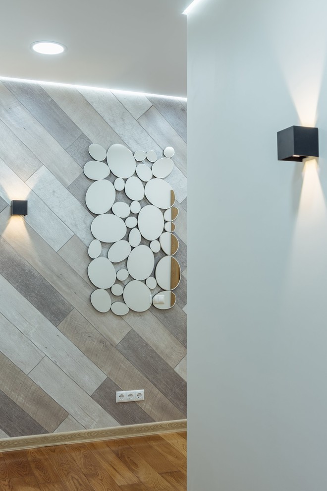 Idee per un grande corridoio scandinavo con pareti bianche e pavimento in legno massello medio