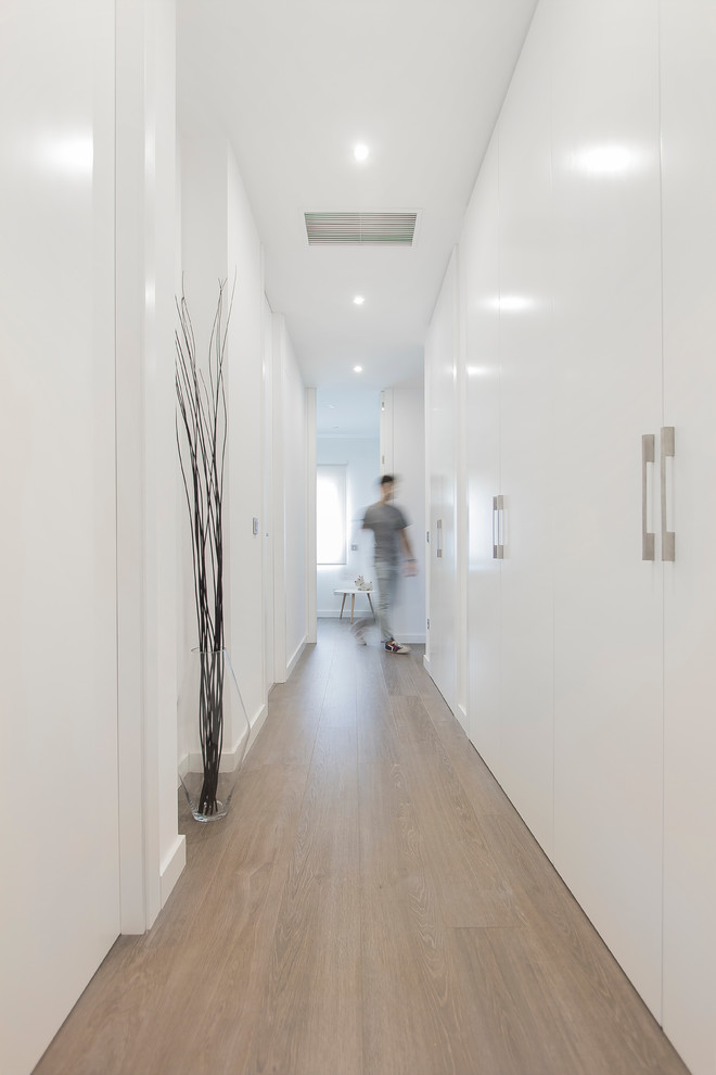 Идея дизайна: коридор среднего размера в стиле модернизм с белыми стенами и паркетным полом среднего тона