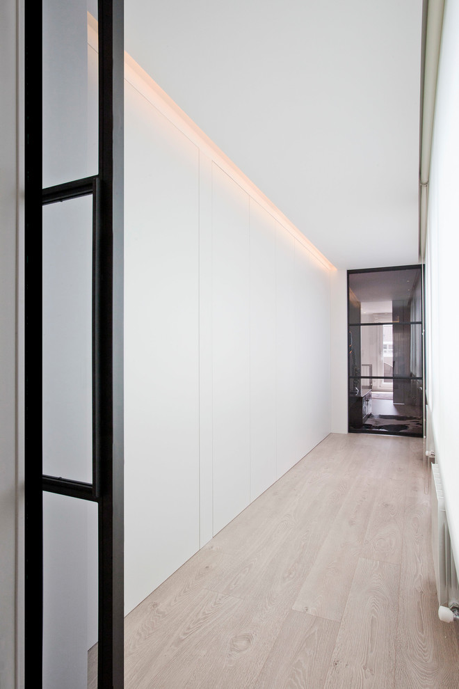 Kleiner Moderner Flur mit weißer Wandfarbe, hellem Holzboden und braunem Boden in Sonstige