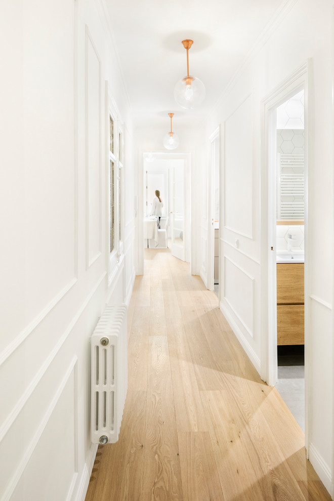 Immagine di un ingresso o corridoio scandinavo di medie dimensioni con pareti bianche, pavimento in legno massello medio e pavimento marrone