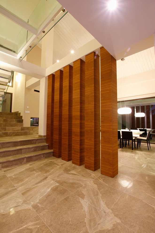 Ejemplo de recibidores y pasillos minimalistas grandes con paredes blancas, suelo de mármol y suelo marrón