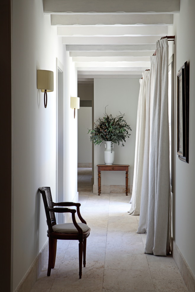 Imagen de recibidores y pasillos mediterráneos de tamaño medio con paredes blancas y suelo beige