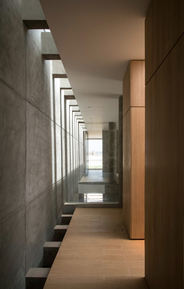 Réalisation d'un grand couloir design avec un mur gris.