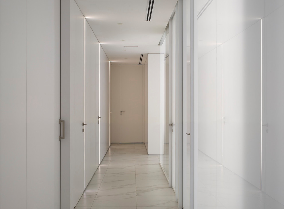 Cette photo montre un grand couloir moderne en bois avec un mur blanc et un sol blanc.