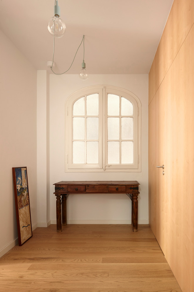 Ejemplo de recibidores y pasillos mediterráneos de tamaño medio con paredes blancas, suelo de madera en tonos medios y suelo marrón