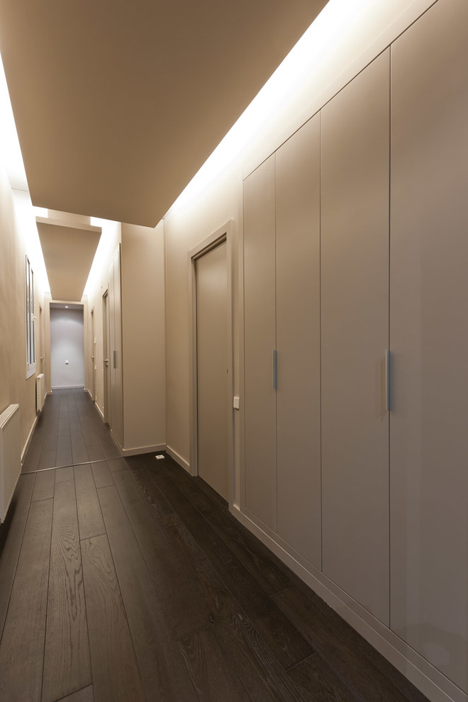 Aménagement d'un grand couloir moderne avec un mur beige et parquet peint.