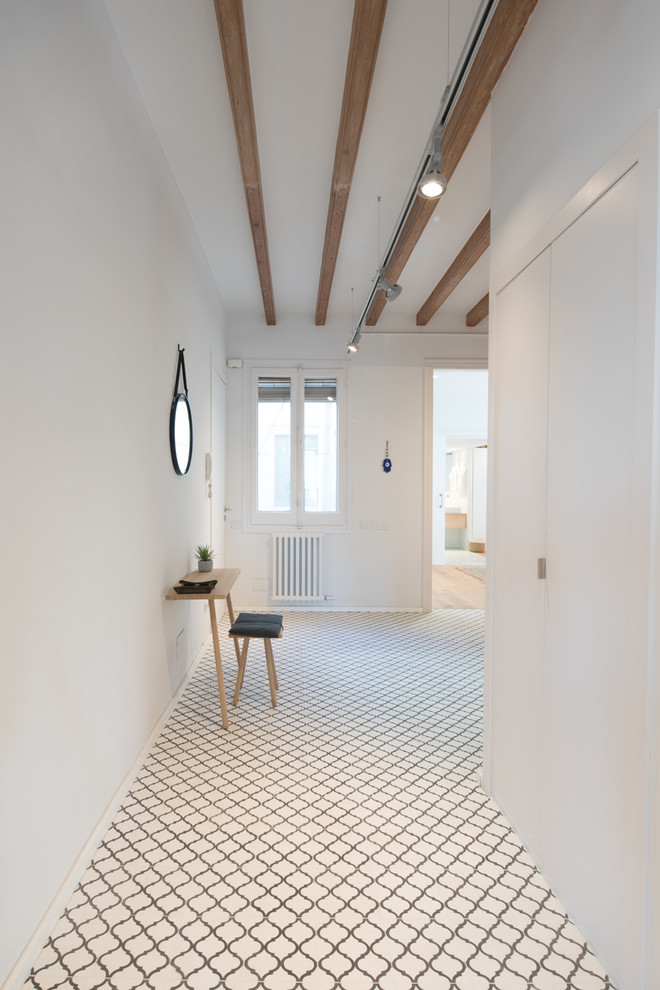 Inspiration pour un couloir design de taille moyenne avec un mur blanc et un sol blanc.