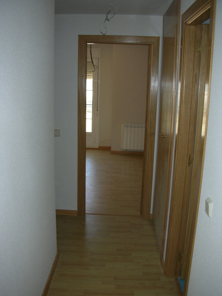 Imagen de recibidores y pasillos modernos pequeños con paredes blancas, suelo de madera clara y suelo marrón