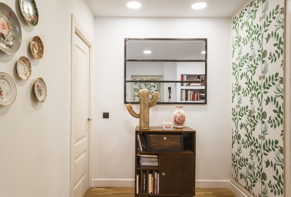 Imagen de recibidores y pasillos tropicales pequeños con paredes blancas y suelo de madera en tonos medios