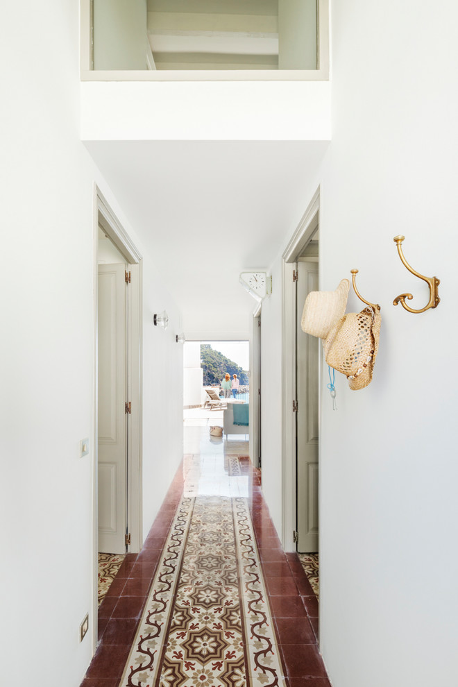 Пример оригинального дизайна: коридор среднего размера в средиземноморском стиле с белыми стенами, полом из керамической плитки и разноцветным полом