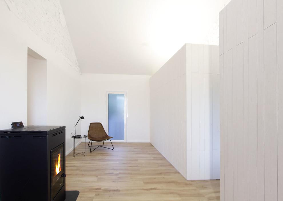 Idee per un piccolo ingresso o corridoio scandinavo con pareti bianche, parquet chiaro e pavimento marrone