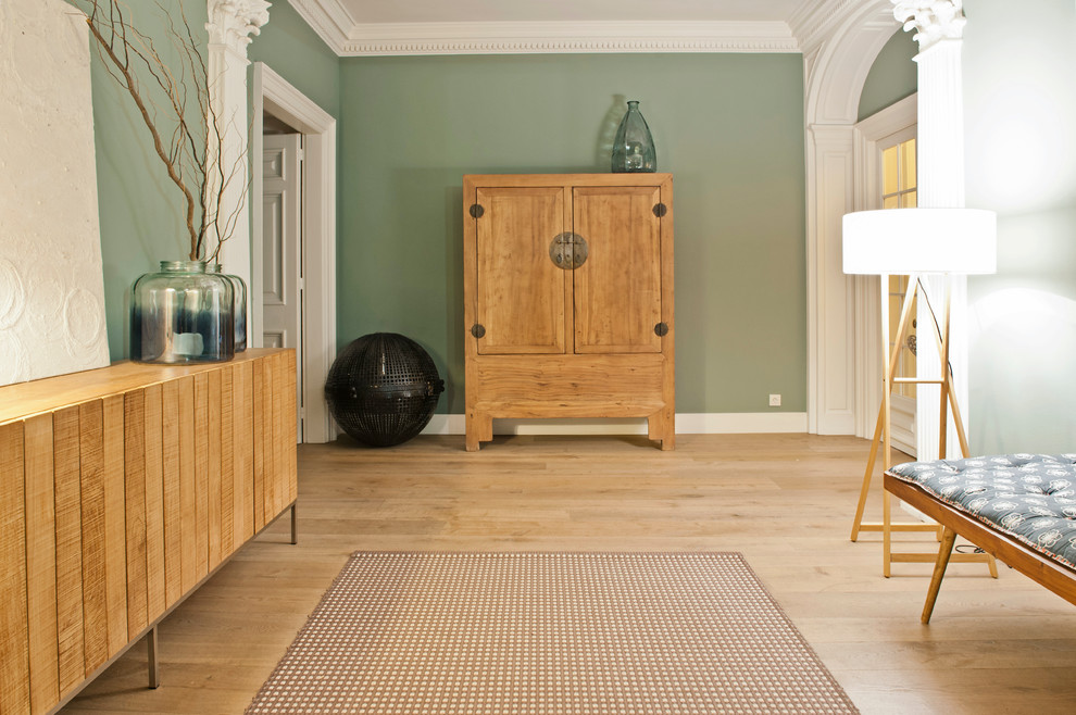 Cette photo montre un couloir chic de taille moyenne avec un mur vert, un sol en bois brun et un sol marron.