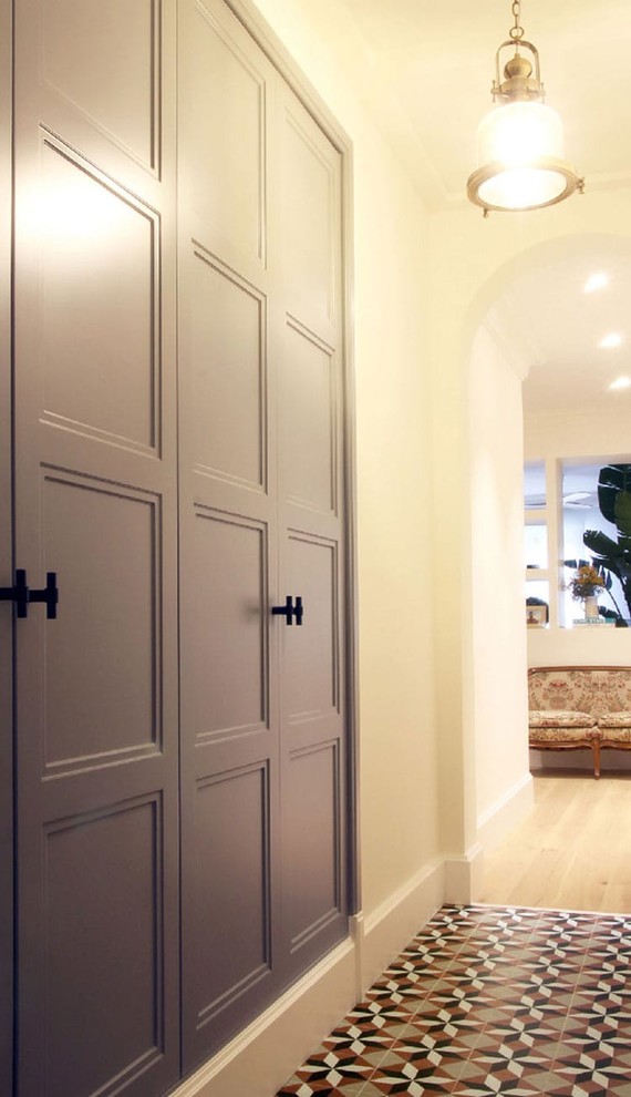 Immagine di un ingresso o corridoio design di medie dimensioni con pareti bianche, pavimento in legno massello medio e pavimento marrone
