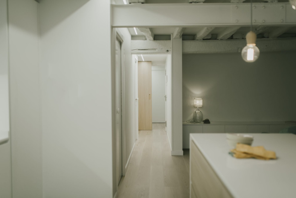 На фото: большой коридор в стиле модернизм с коричневым полом и балками на потолке с