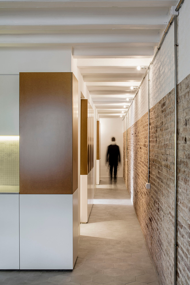 Idée de décoration pour un couloir urbain de taille moyenne avec un mur marron et un sol en carrelage de céramique.
