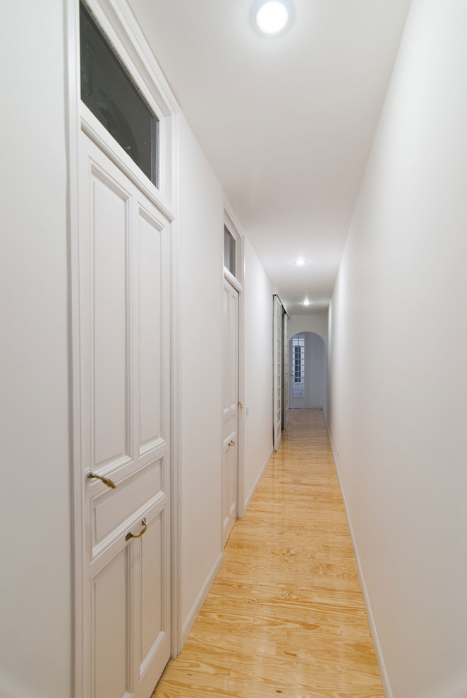 Foto de recibidores y pasillos tradicionales renovados de tamaño medio con paredes blancas, suelo de madera clara y suelo amarillo