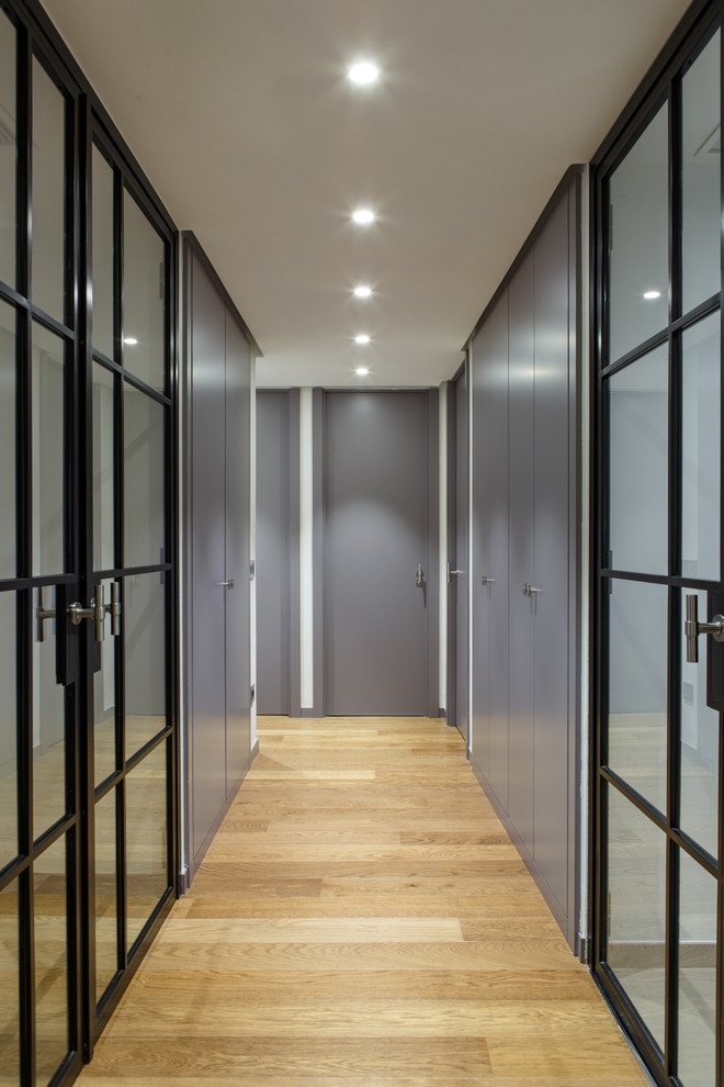На фото: большой коридор в современном стиле с серыми стенами, паркетным полом среднего тона и коричневым полом с