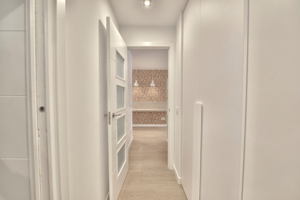 Ispirazione per un ingresso o corridoio nordico di medie dimensioni con pareti bianche e pavimento in laminato