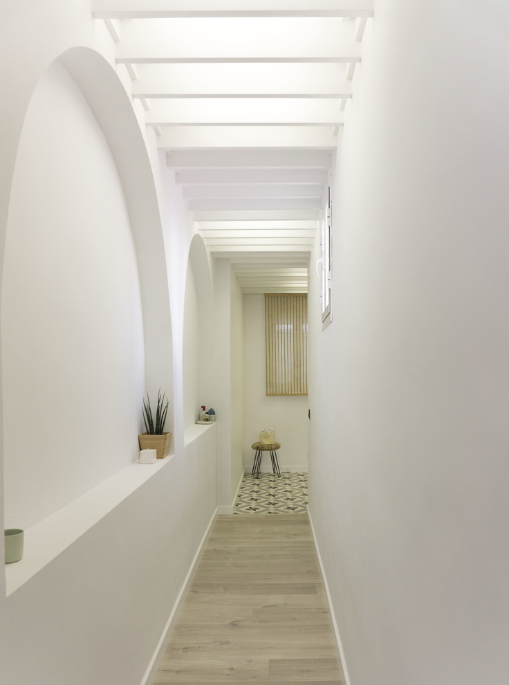 Diseño de recibidores y pasillos escandinavos de tamaño medio con paredes blancas y suelo de madera en tonos medios