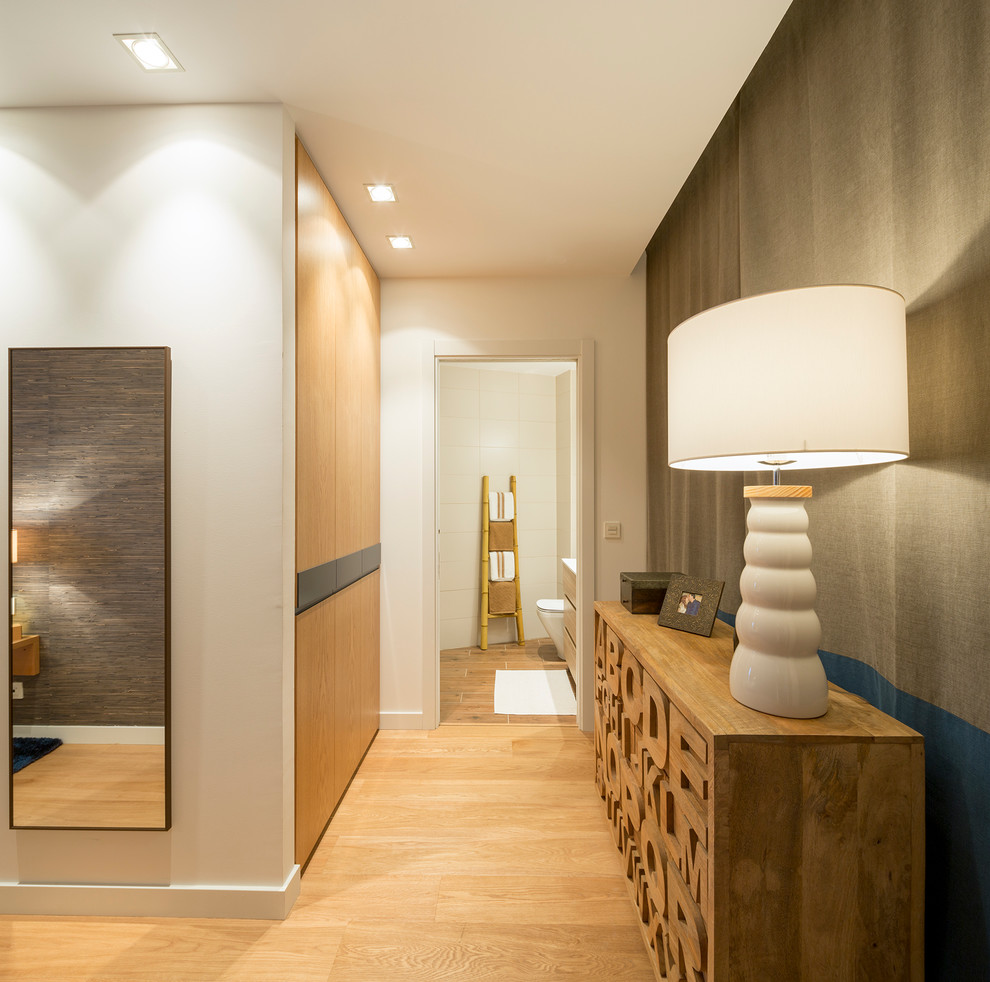 Réalisation d'un couloir design de taille moyenne avec un mur blanc et un sol en bois brun.